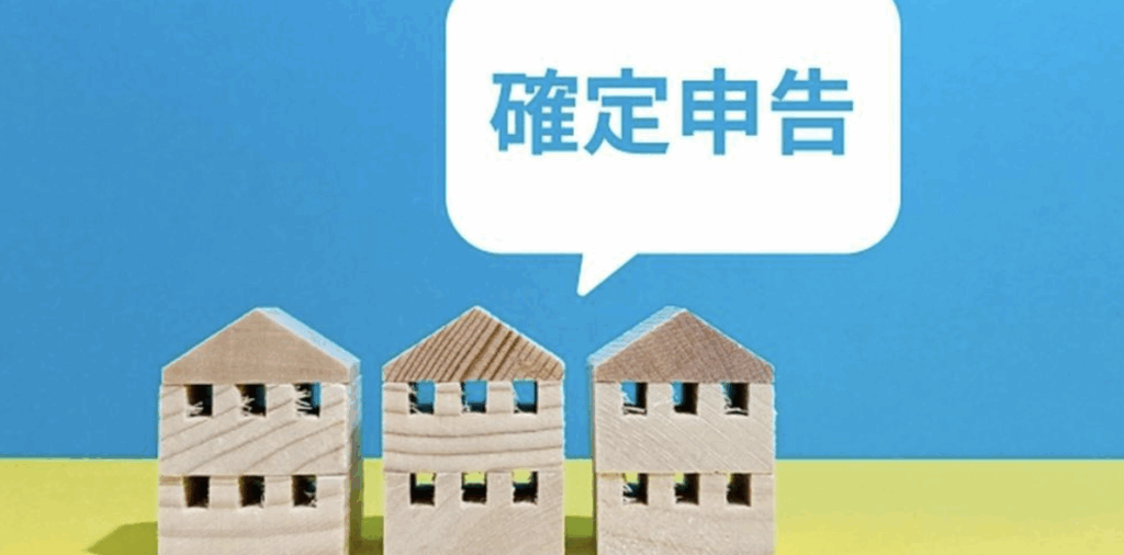 「確定申告」の吹き出しと木の家の模型3つが並んでいる画像